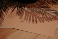 a card with the words beauty by lin sitting on top of a wooden table