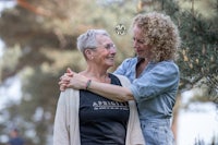 two women hugging each other in a park